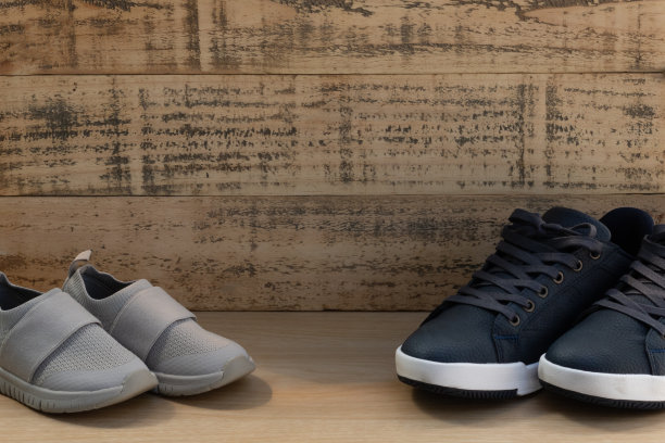大的和小的运动鞋鞋在木制背景。父亲节的庆祝活动。图片下载
