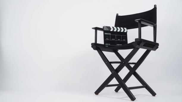 黑色拍板或电影板与导演椅，用于视频制作或电影和电影行业。背景是白色的。图片下载