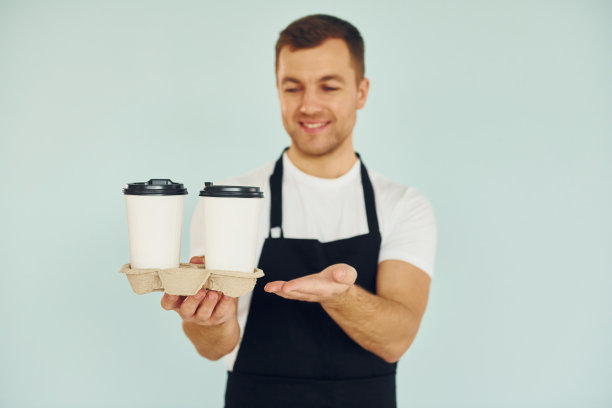 穿着制服的男人站在演播室里，手里拿着饮料图片下载