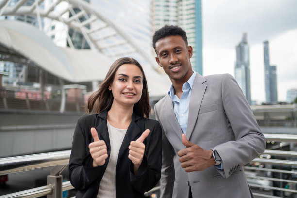 非洲经理和商务人士站在城市中心、商务区。拿到新项目后，竖起大拇指微笑。工人们为好消息而高兴。团队合作和头脑风暴概念图片下载