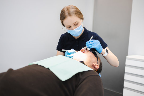 女牙医正在检查男病人的牙齿图片下载