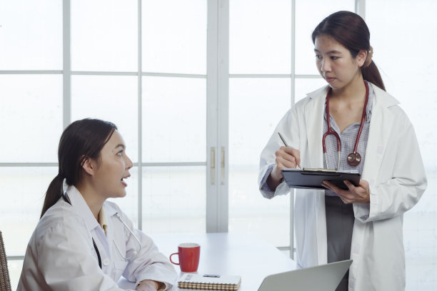 4k的时候，一名身穿白衬衫的亚裔女医学院学生向她征求建议。在医院的办公室里谈论病人的病情和医生的老师图片下载