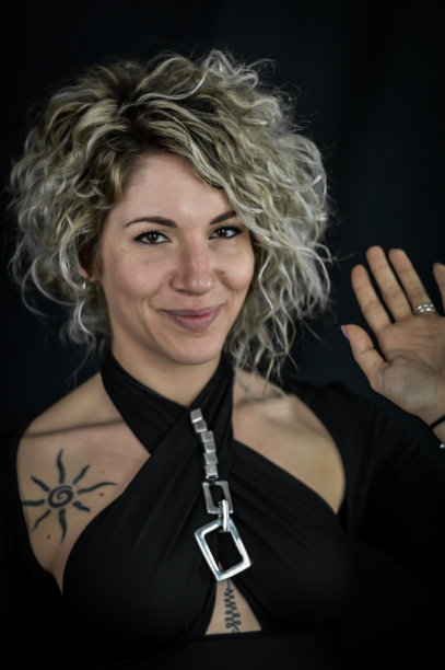 一个美丽的微笑卷曲的金发女人举起她的手成为志愿者的肖像图片下载