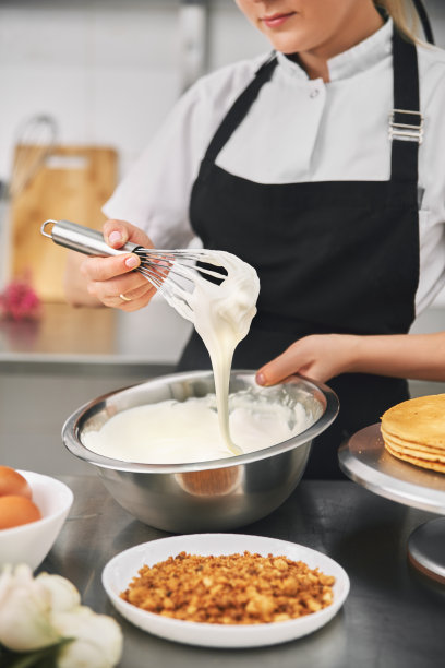 穿着黑色制服的糖果师在糖果店工作。图片下载