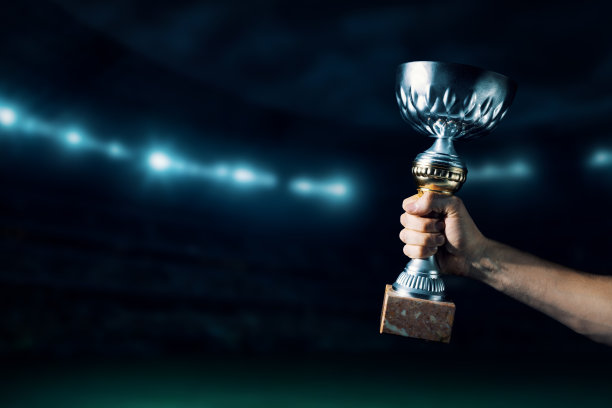 胜者手举着奖杯站在球场的背景上。本空间图片下载