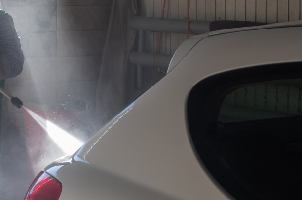 在车库里用水枪冲洗白色汽车图片下载