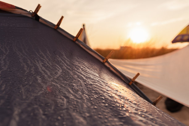 在夕阳的照射下，游客帐篷织物纹理上的冷凝水滴图片下载