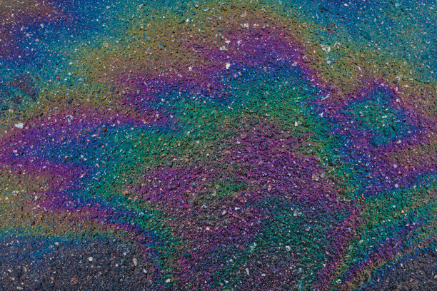 石油、天然气或汽油在沥青或沥青上的彩虹点图片下载