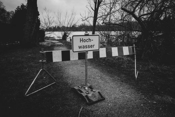 在被洪水淹没的道路上有一块牌子，上面写着“洪水泛滥”图片下载