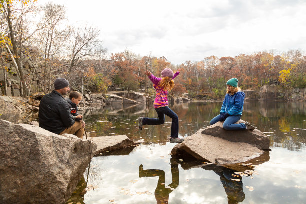 女孩在湖上的岩石间跳跃图片下载