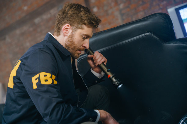 一个联邦调查局探员俯视犯罪现场，我们看到了他的侧面图片下载