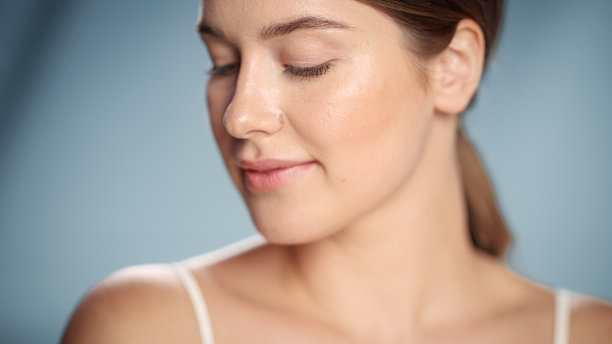 女性美丽的肖像。美丽的白人妇女与棕色头发摆姿势在相机上，她的自然皮肤是干净的。柔软孤立背景下的健康护肤理念。关闭了。图片下载