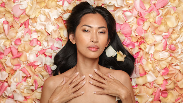 躺在花坛上的美女画像。美丽的亚洲黑发女人与自然，清洁，健康的皮肤摆姿势和微笑。健康，水疗，美容和护肤品的概念。图片下载