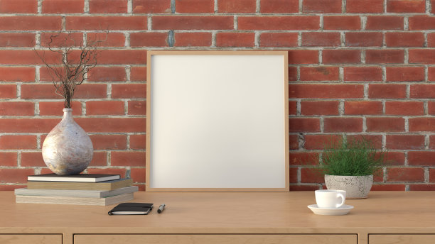 方形木制图片海报框架模型。木桌上放着咖啡、书、花瓶和笔记本。红砖墙背景。图片下载
