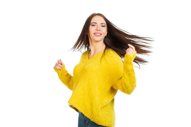 身着黄色毛衣，面带微笑的年轻女孩，头发蓬乱，翩翩起舞。图片下载