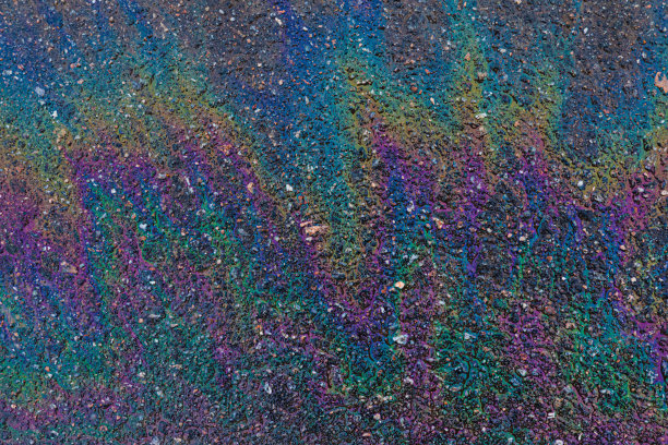 石油、天然气或汽油在沥青上形成彩虹图片下载