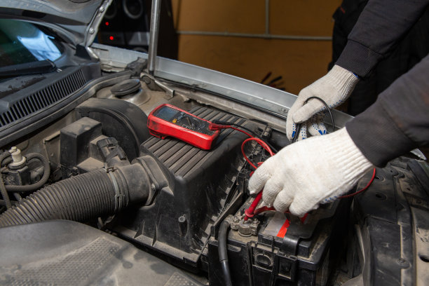 选择性聚焦汽车修理工用万用表电压表检查汽车电池的电压水平。图片下载