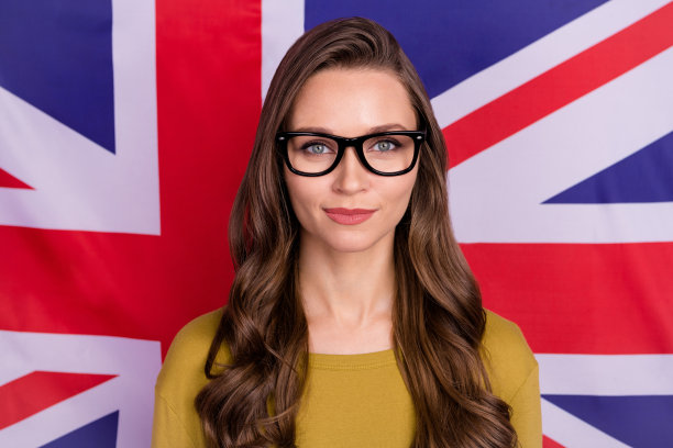 在英国国旗的背景下，聪明的聪明的漂亮的女士看相机孤立的照片图片下载