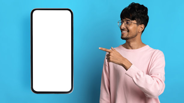 快乐的印度千禧一代男子展示了空屏幕的智能手机图片下载