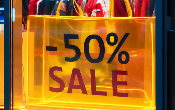 50%的销售，专卖店和销售标志在商店橱窗展示。购物与折扣概念图片下载