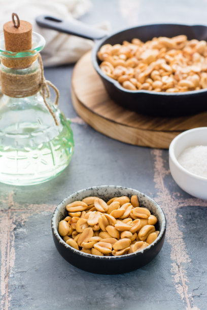 在碗里烤花生，在煎锅里，在桌子上放一碗盐。植物蛋白质来源。素食。俯视图图片下载