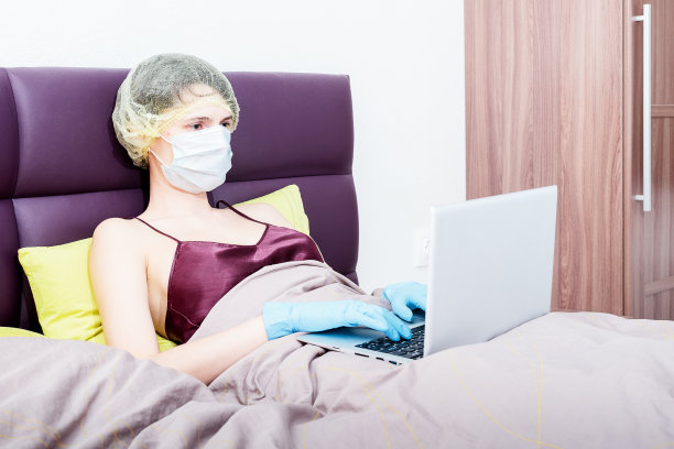 COVID-19冠状病毒自我隔离和在家工作。一个戴着防护手套、面罩和帽子的女孩图片下载