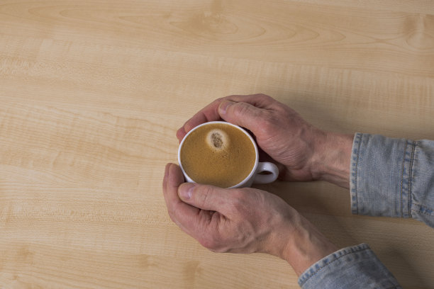 男性手握热咖啡杯的特写镜头。图片下载