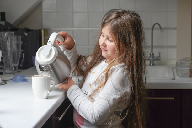 一个小女孩在家帮忙做早餐。家庭、隔离、家庭教育理念。图片下载