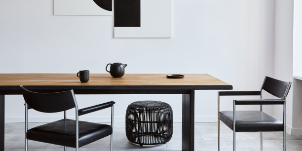 时尚的餐厅室内设计木制家庭桌子，黑色的椅子，茶壶与马克杯，模拟艺术绘画在墙上和优雅的配件在现代家居装饰。模板。图片下载