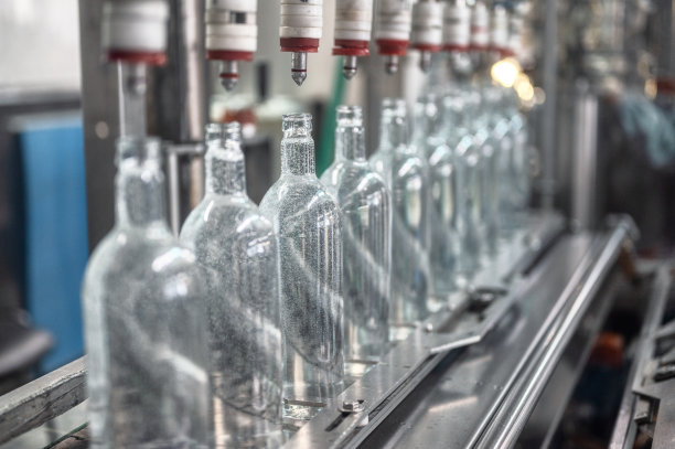 在生产线上为玻璃瓶灌装伏特加饮料图片下载