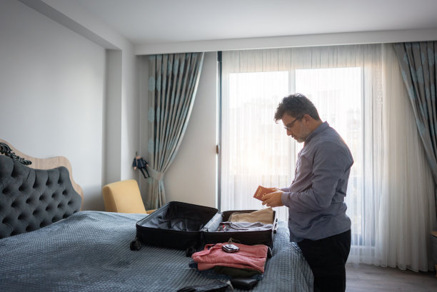 成熟的商人在酒店房间里检查他的护照。图片下载