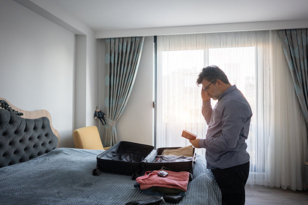 成熟的商人在酒店房间里检查他的护照。图片下载