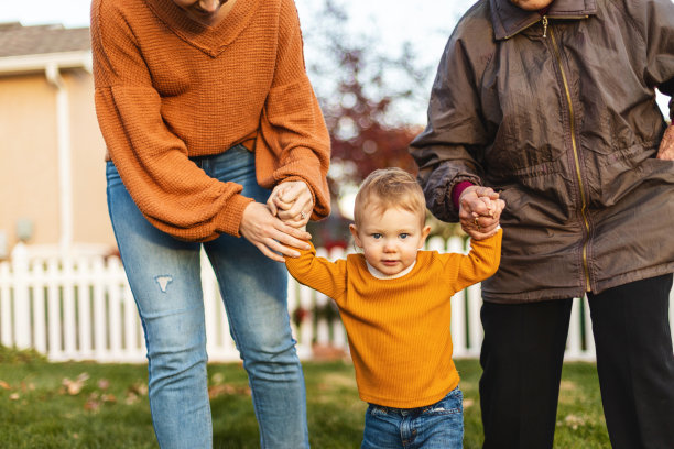 夏末初秋的照片系列，男孩和母亲、祖母一起在院子里玩耍图片下载