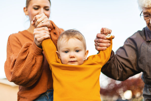 夏末初秋的照片系列，男孩和母亲、祖母一起在院子里玩耍图片下载