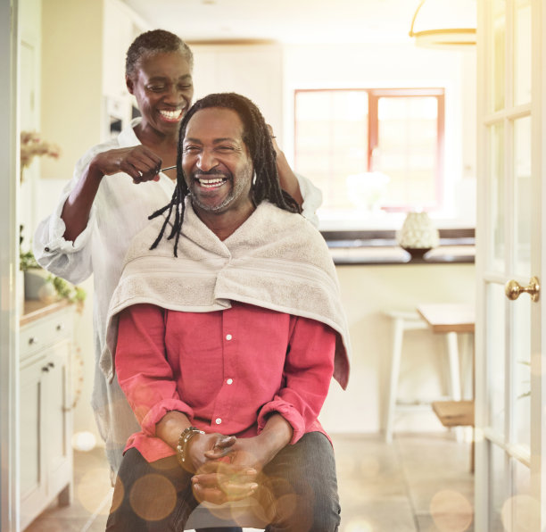 这张照片拍摄于一位老妇人在家里的厨房里给她的丈夫梳脏辫图片下载