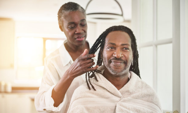 这张照片拍摄于一位老妇人在家里的厨房里给她的丈夫梳脏辫图片下载