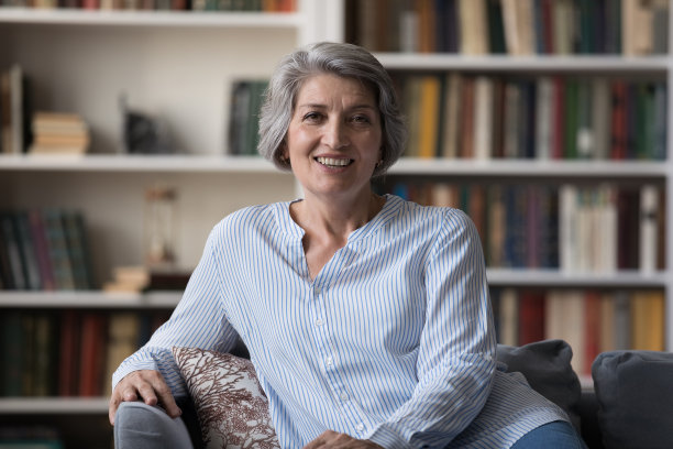 快乐迷人的中年退休妇女看着相机。图片下载