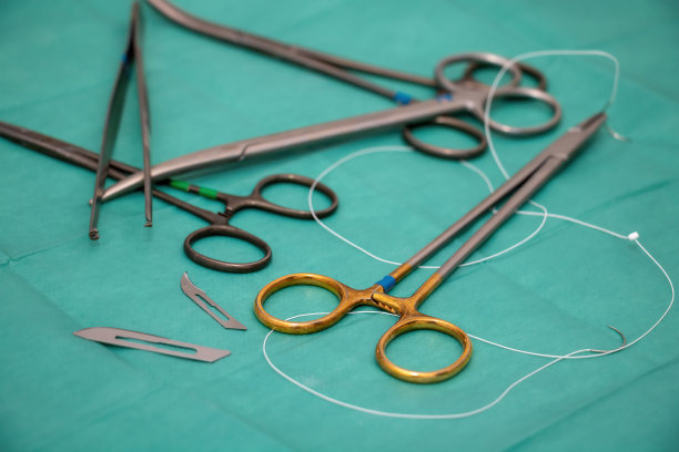 无菌手术器械，绿色织物背景。外科医生用不锈钢工具。图片下载