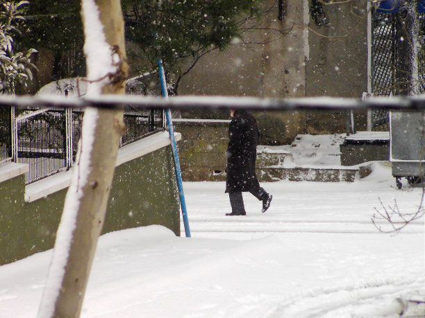 一个在冬天雪地里行走的老人图片下载