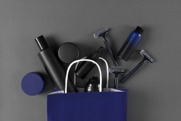 男士护肤品纸袋。男性美容化妆品产品的灰色背景。俯视图，平躺图片下载