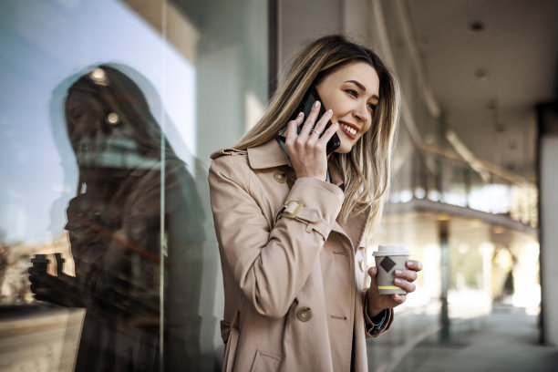 女商人在户外喝咖啡休息时用智能手机聊天图片下载