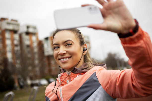 一名微笑的年轻女子在早上慢跑时自拍图片下载