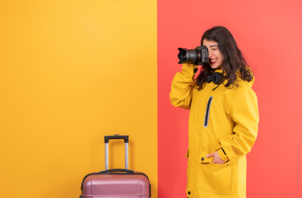 女旅行者摄影师与数码单反相机彩色背景。图片下载