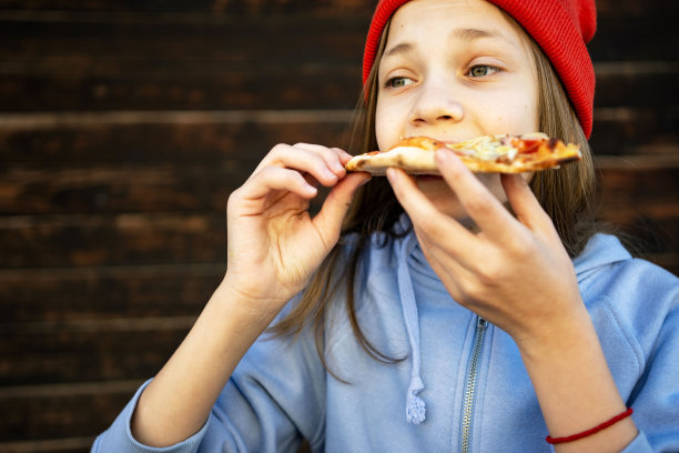 十几岁的女孩在户外吃披萨图片下载