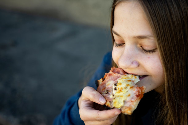 十几岁的女孩在户外吃披萨图片下载