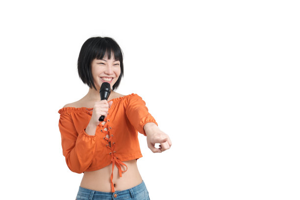 一个年轻的亚洲女人对着麦克风说话，指着别人，孤立无援。图片下载