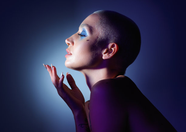 工作室拍摄了一个迷人的年轻女子，在蓝色的背景下化妆图片下载