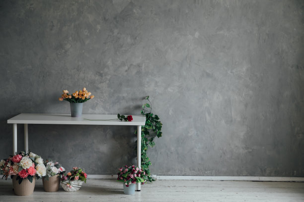一个灰色房间的内部，白色的桌子和鲜花图片下载