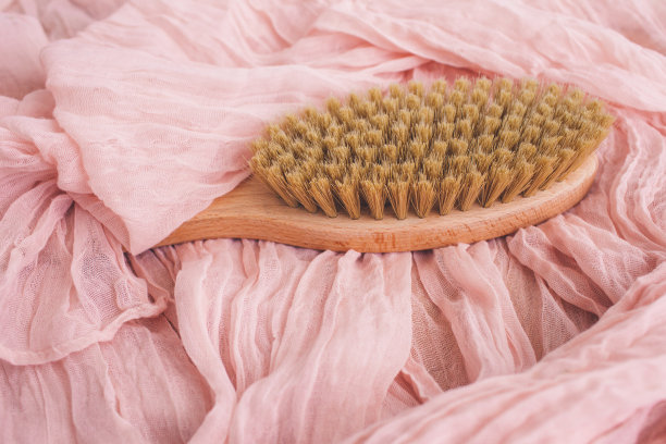 木刷在粉红色的背景干按摩。侘寂的美学。天然材料。图片下载