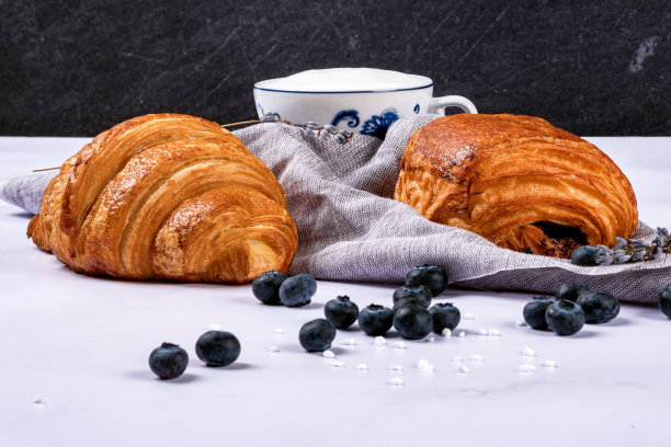 羊角面包和甜糕点充满了巧克力，在大理石纹理背景上的新鲜浆果。图片下载